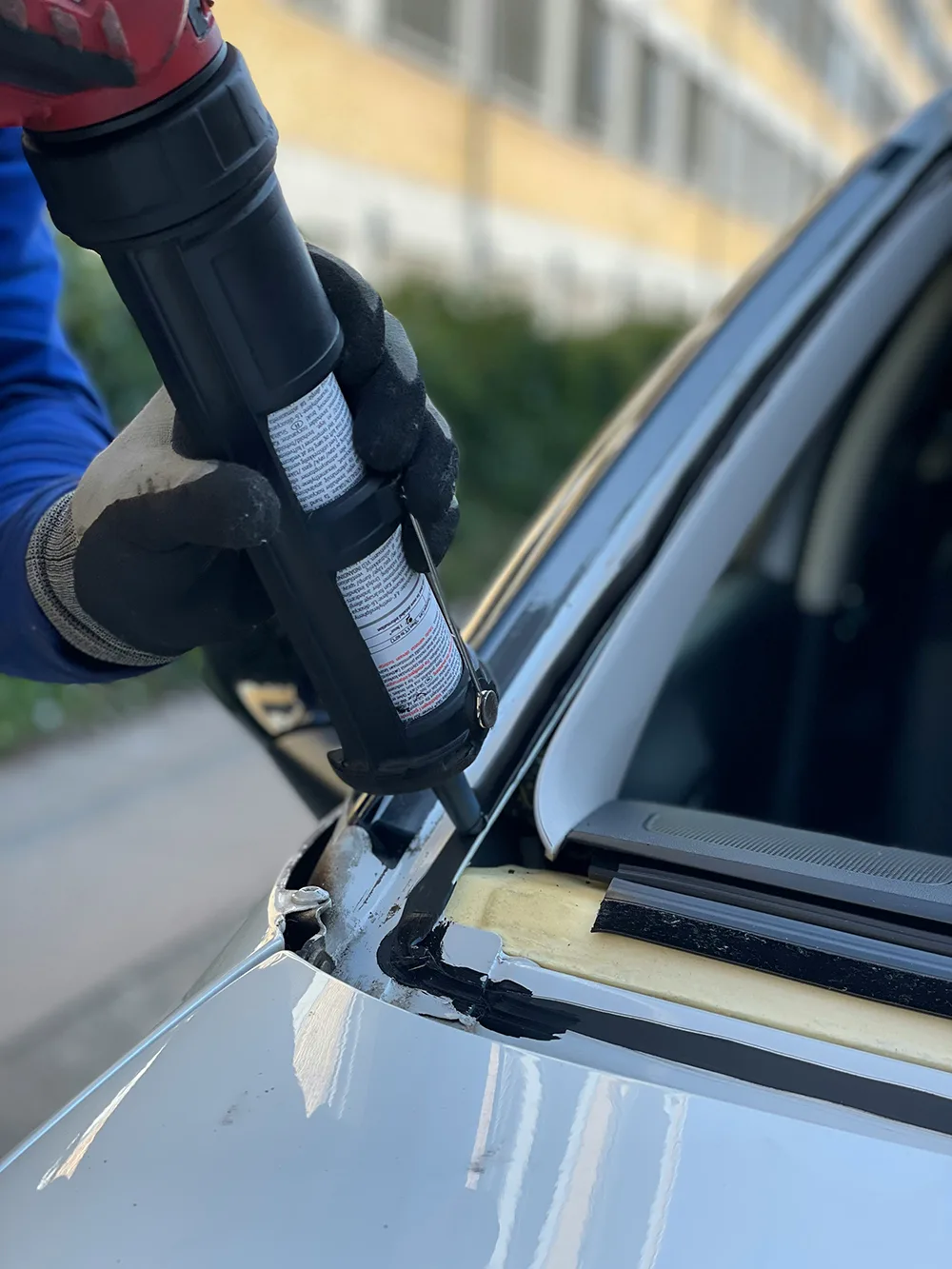 Technician applying urethane adhesive for a windshield install