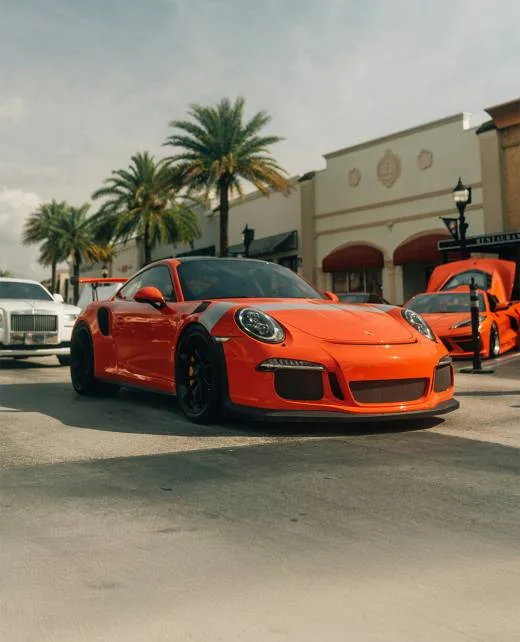 An orange Porsche outside Pristine Collision Center