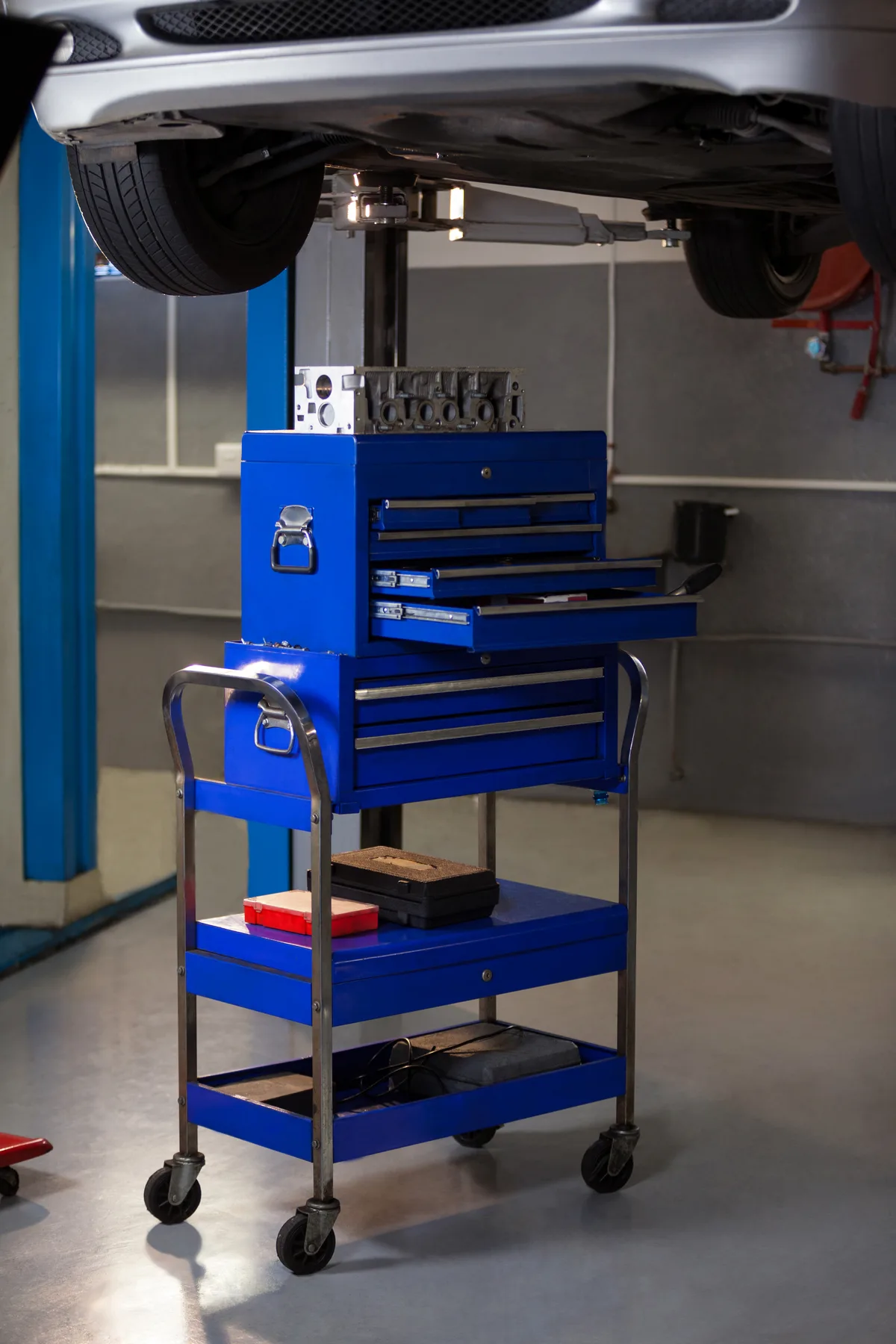Professional tool cart beneath a vehicle on a lift