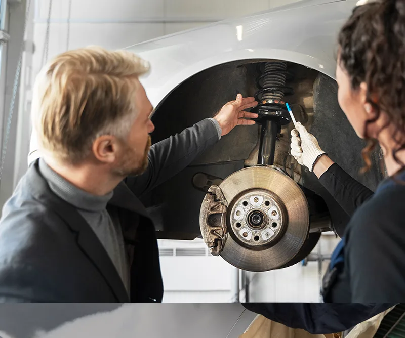 Technicians servicing a wheel hub and suspension