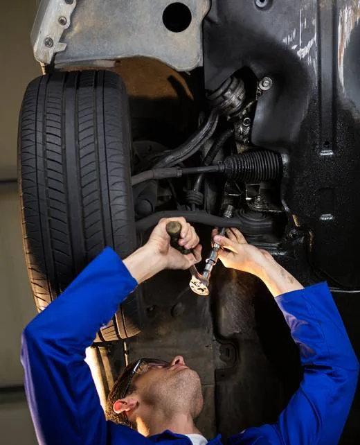 Mechanic adjusting suspension under a vehicle